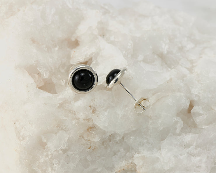 Silver dangle black onyx stud earrings on white rock