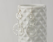 Silver hammered circles earrings on geometric vase