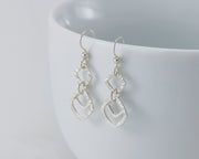 Silver hammered squares earrings on white cup