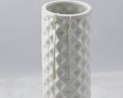 silver bar earrings on geometric vase