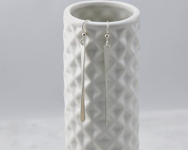 silver bar earrings on geometric vase