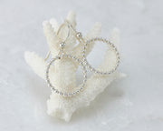 Silver beaded circle hoop earrings on coral