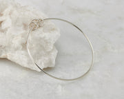 bangle silver charms bracelet open on white rock