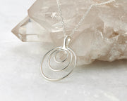 Silver circles necklace on crystal rock