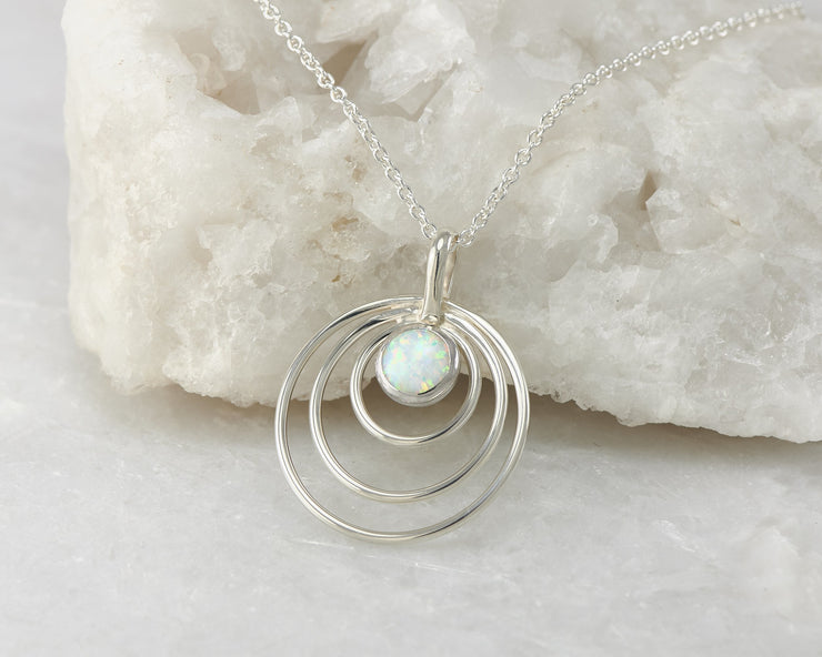 Silver opal circles necklace on white rock