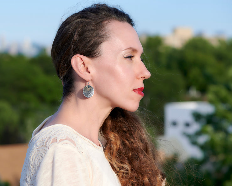Woman wearing silver hammered discs earrings