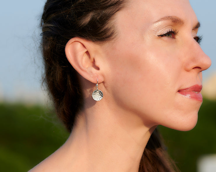 Silver earrings being worn by a woman