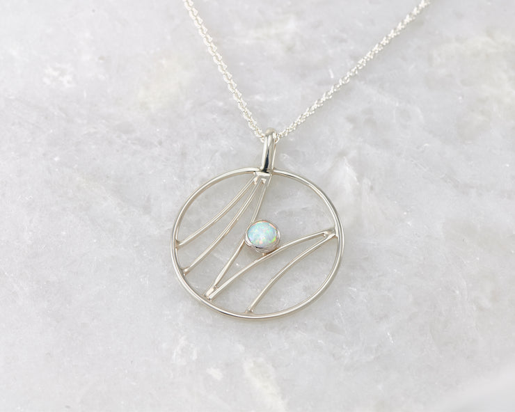 silver opal pendant on white marble