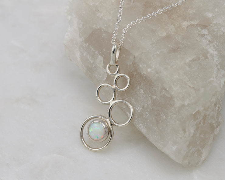 Silver opal pendant on crystal rock
