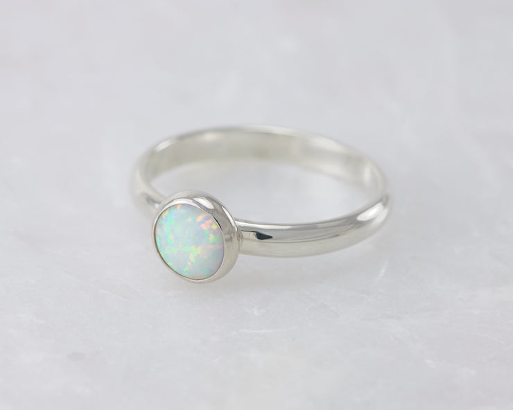 simple opal silver ring on white marble