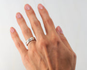 woman wearing 3 silver stacking rings of different finishes