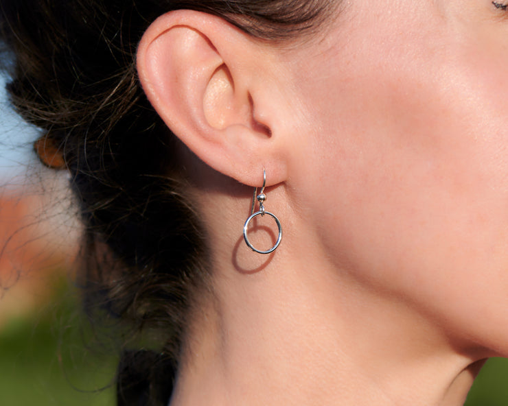 close up of woman wearing silver small hoop earrings