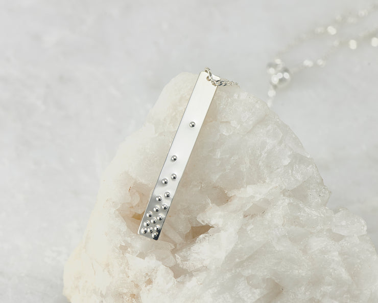 Silver bar y-necklace on white rock
