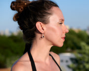 Woman wearing silver hoop black onyx earrings