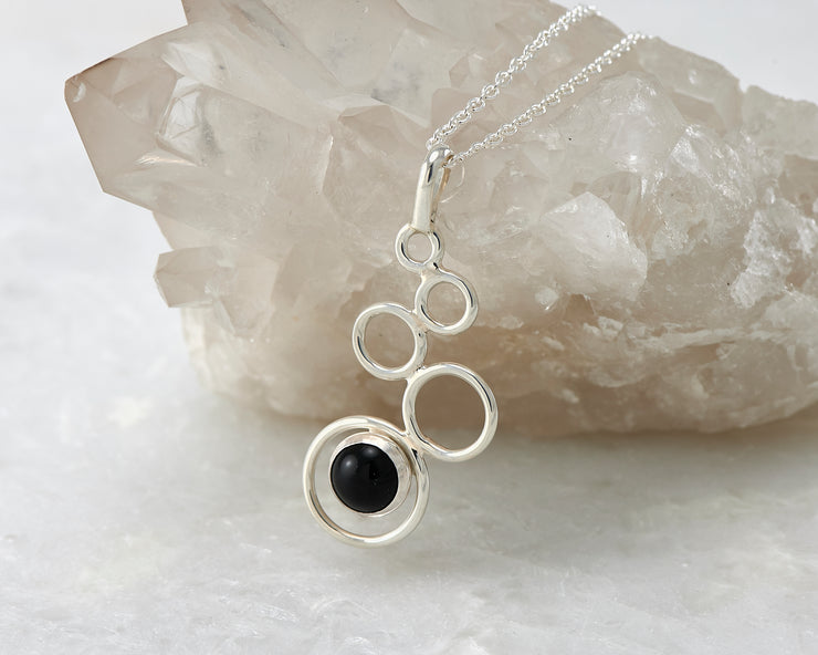 Silver black onyx pendant on crystal rock