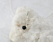 Silver black onyx pendant on white rock