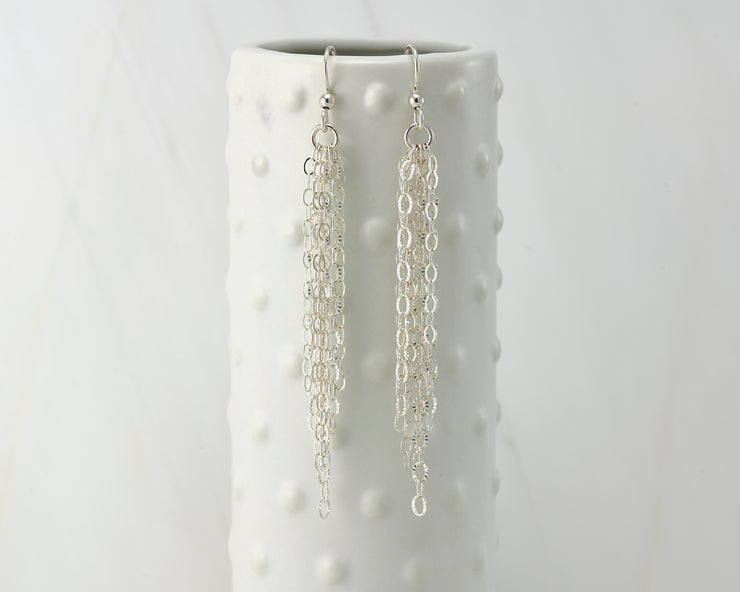 Silver chandelier earrings on dotted vase
