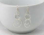 Silver hammered circles earrings on white cup
