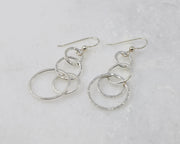 Silver polished hammered circles earrings on white marble