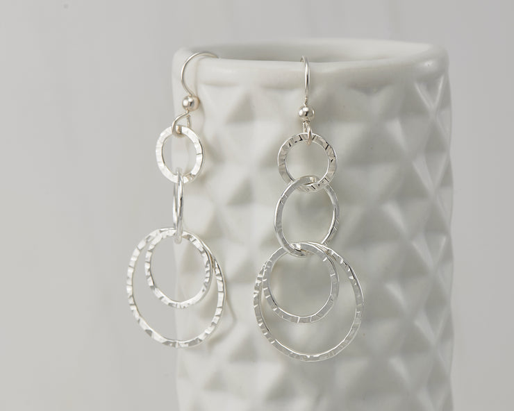 Silver hammered circles earrings on geometric vase