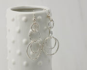 Silver polished hammered circles earrings on dotted vase