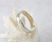 Silver hammered ring on coral