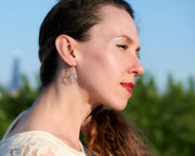 Woman wearing silver hammered hoop earrings
