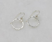 silver hammered hoop earrings on white marble