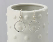 silver hammered hoop earrings on geometric vase