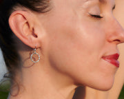 woman wearing silver hammered hoop earrings