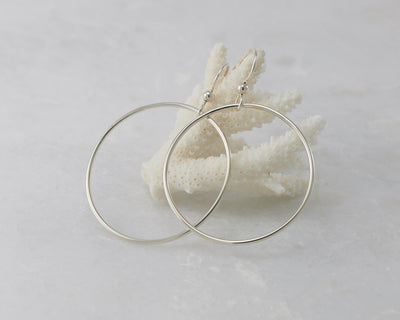 silver large hoop earrings on coral