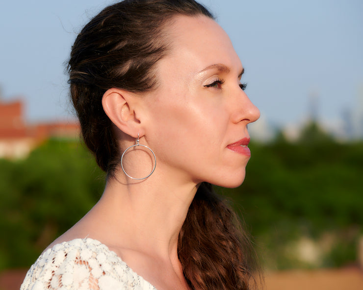 woman wearing silver large hoop earrings