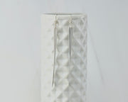 long silver bar earrings on geometric vase