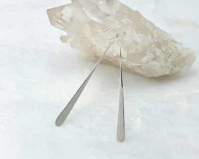 long silver bar earrings on white crystal