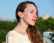 woman wearing long silver bar earrings