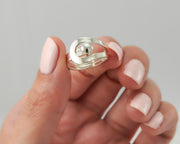 Woman holding modern silver ring