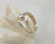 Silver modern ring on coral