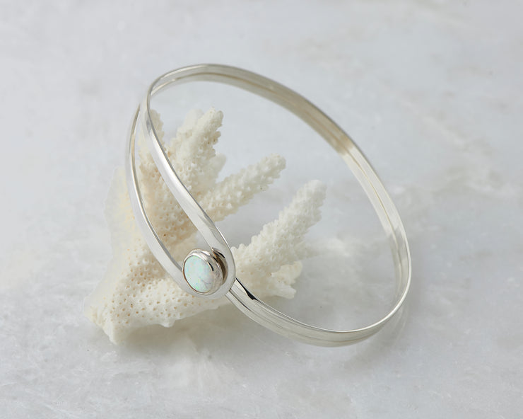 silver latch opal bracelet balanced on coral