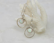 Silver opal earrings on coral