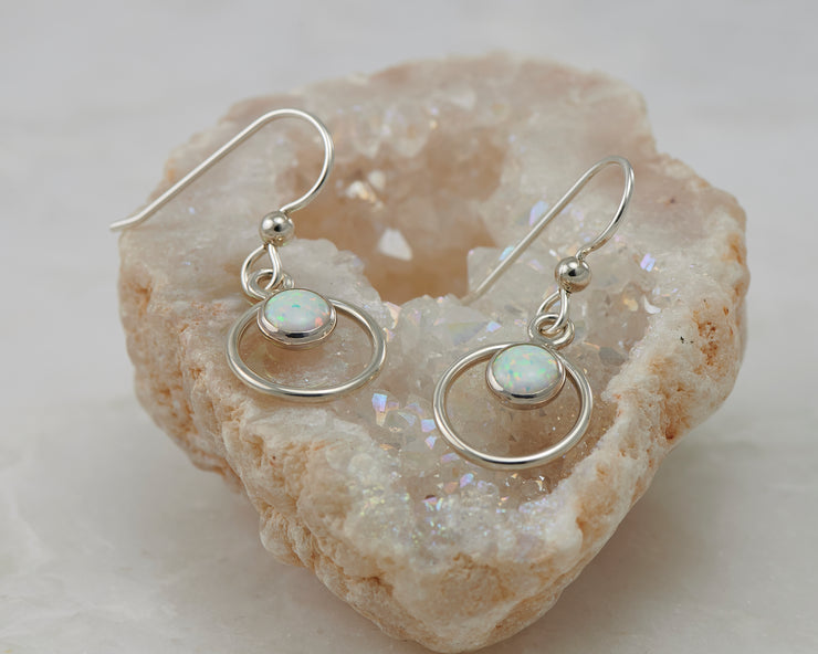 Silver opal earrings on crystal rock