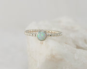 Silver opal beaded ring on white rock