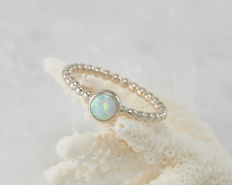 Silver opal ring on coral