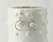 Silver polished pearl hoop earrings on dotted vase