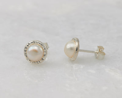 silver pearl stud earrings on white marble