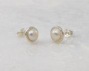 silver pearl stud earrings on white marble