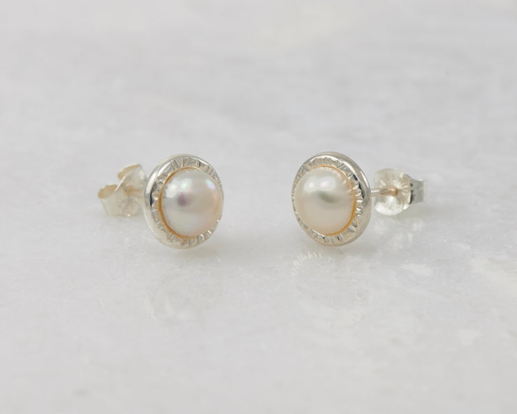 silver pearl stud earrings on white marble