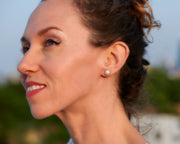 woman wearing silver pearl stud earrings