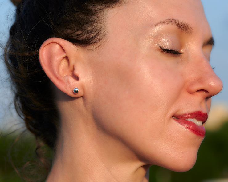 Woman wearing silver ball stud earrings