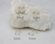 Silver stud earrings size 3mm, 4mm, 6mm, 8mm on white rock