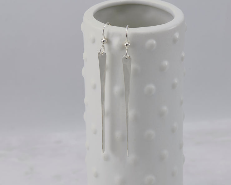 silver bar earrings on dotted vase